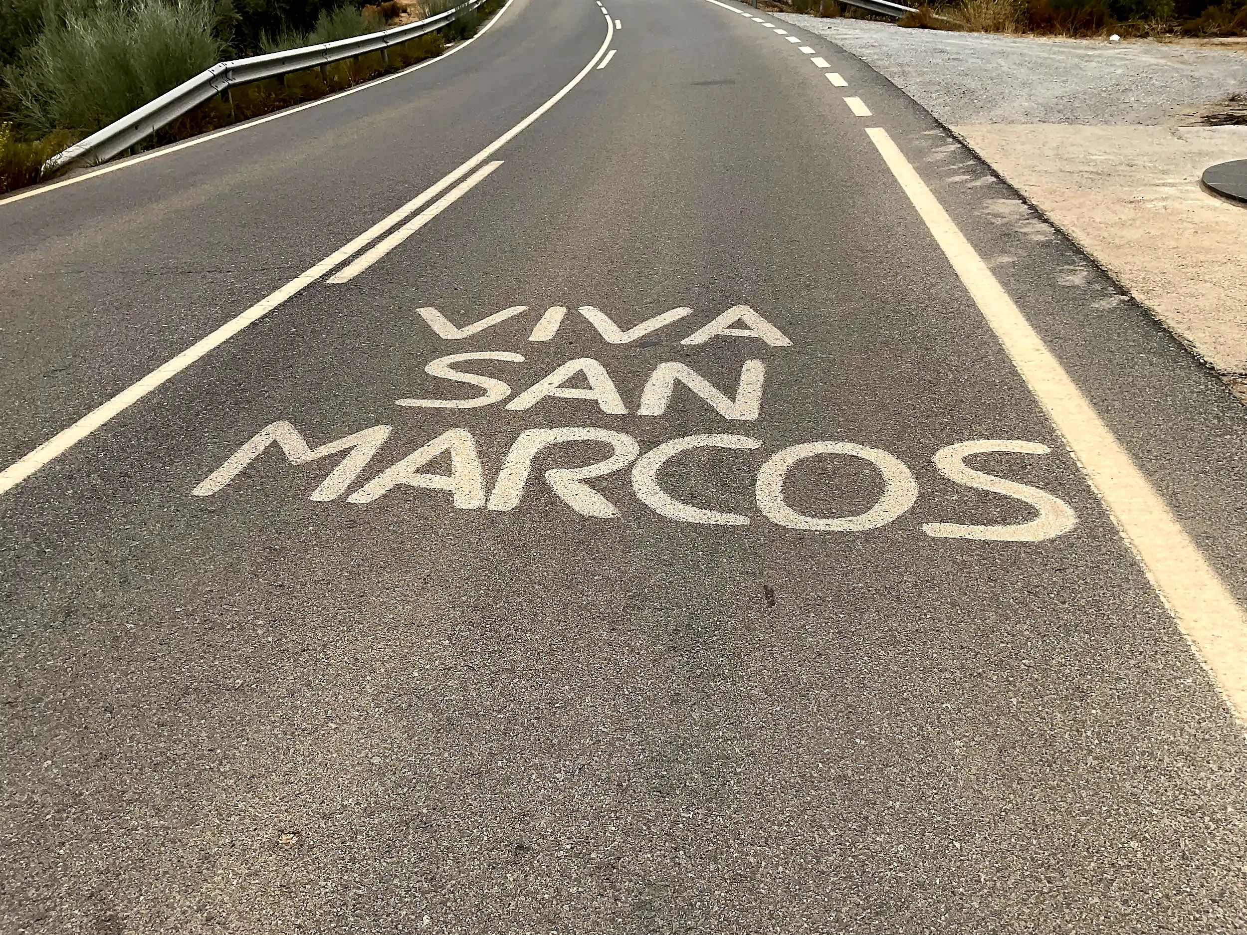 Las palabras Viva San Marcos pintadas sobre el asfalto junto a la cruz